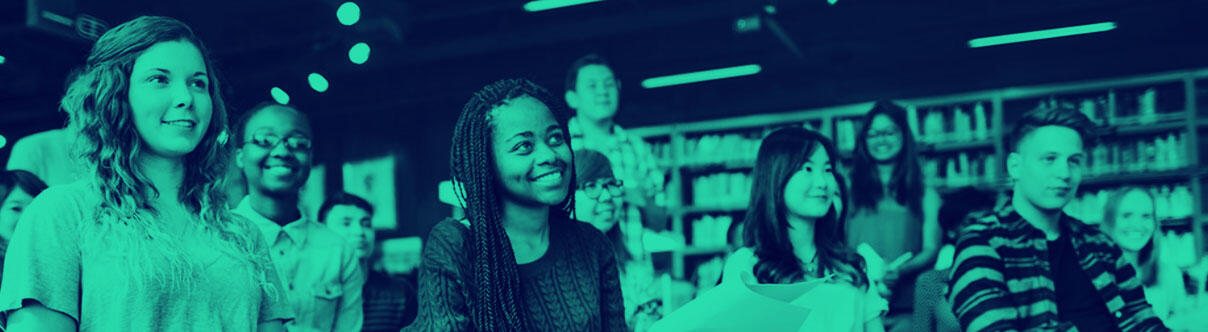 Young people sitting listening to a speaker in a library setting
